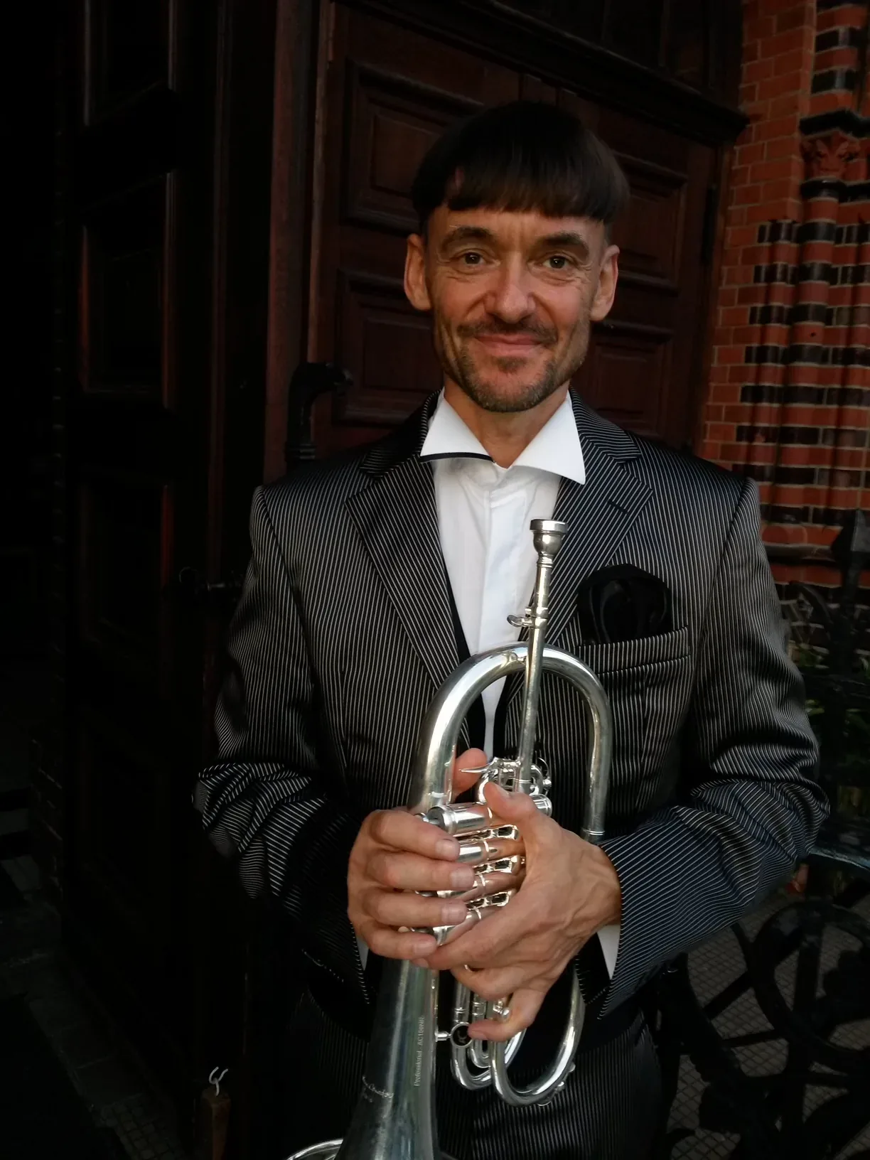 Ron Dietze mit seiner Trompete vor einer Kirche